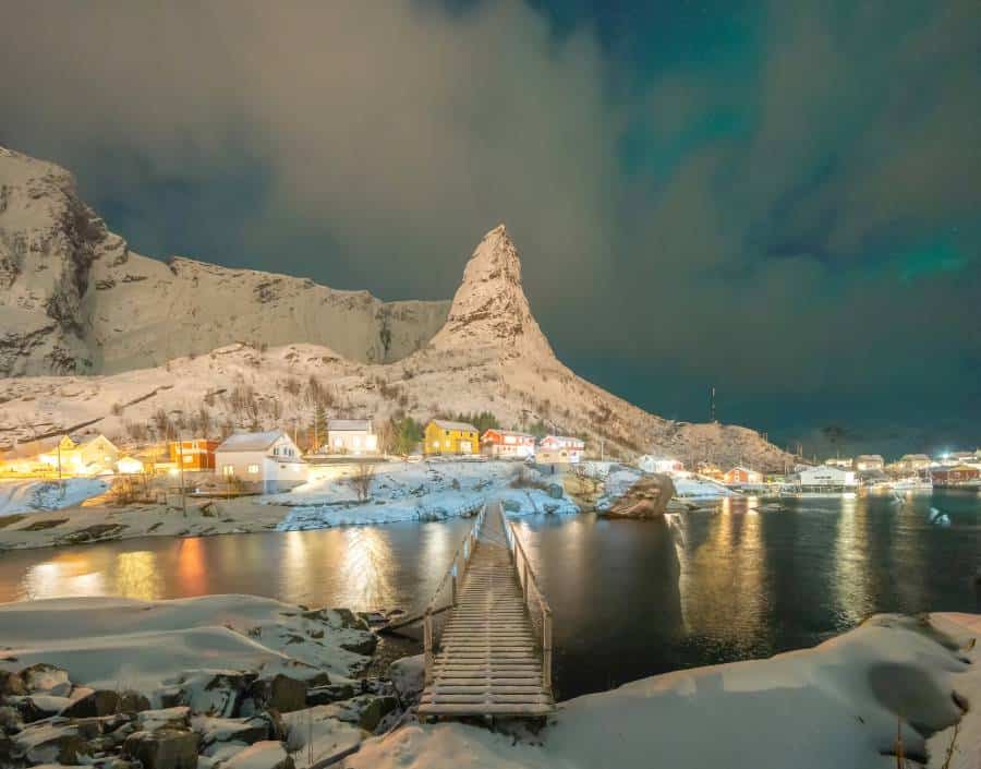 Norwegian fishing village with northern lights and stars in Reine City