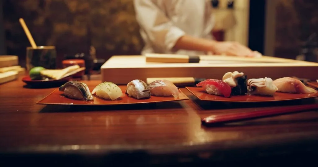 Sushi, plate and serving with chef in restaurant for luxury cuisine